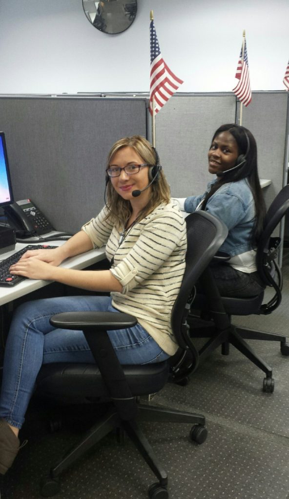 two employees taking calls in their call center booths