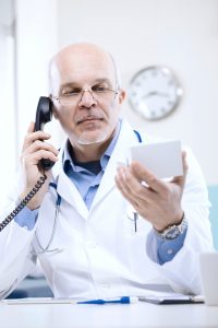 Doctor on the phone with a patient holding a small box