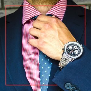 Man fixing his tie wearing a very nice watch
