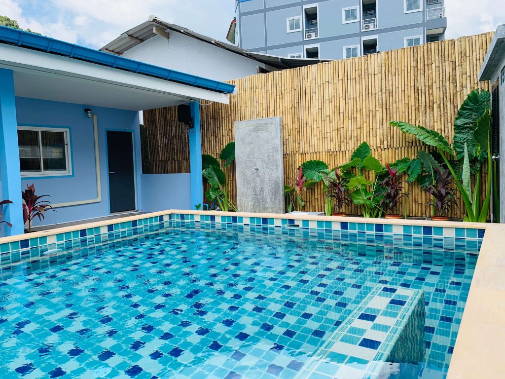 beautiful pool in backyard of house with bamboo fencing